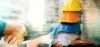 Stacked Construction Hard Hats with miniature homes in the background and 2 hands shaking after rental loan approval.