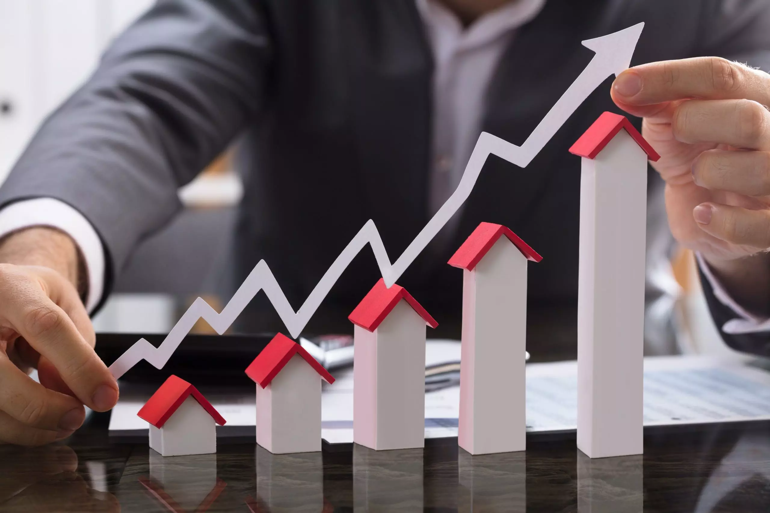 Hard Money lender holding paper graph showing the increase in housing prices