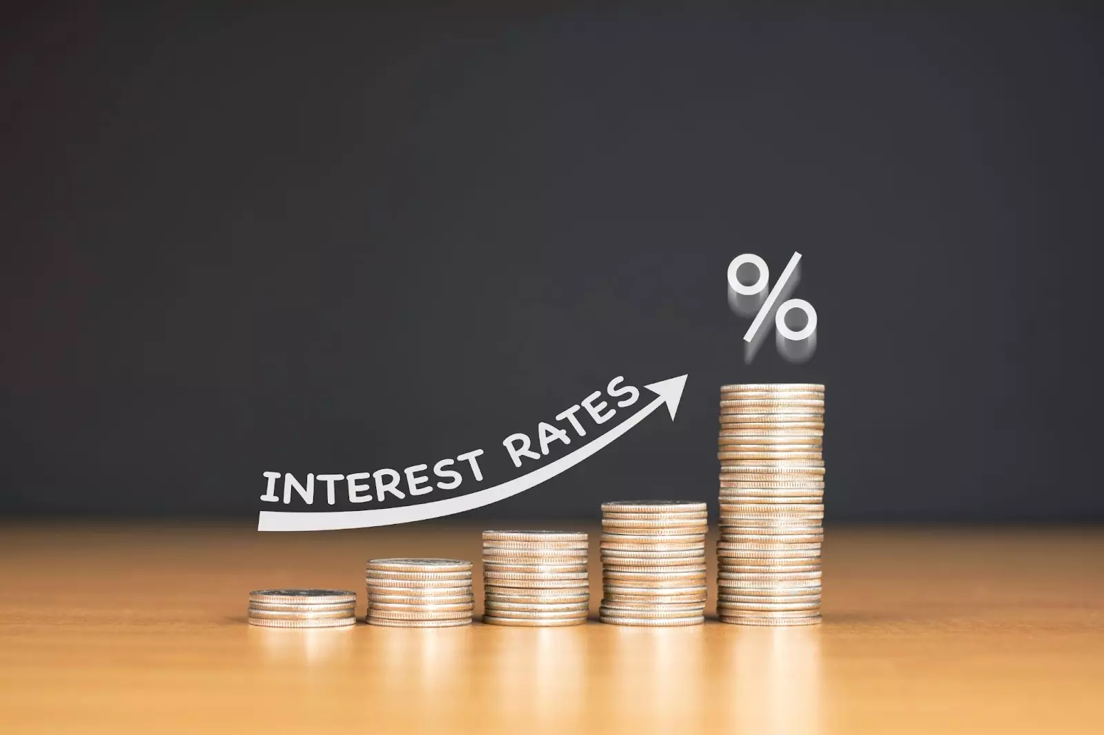 Stacked U.S quarter coins on wooden table with white illustration shows increasing of interest rates.